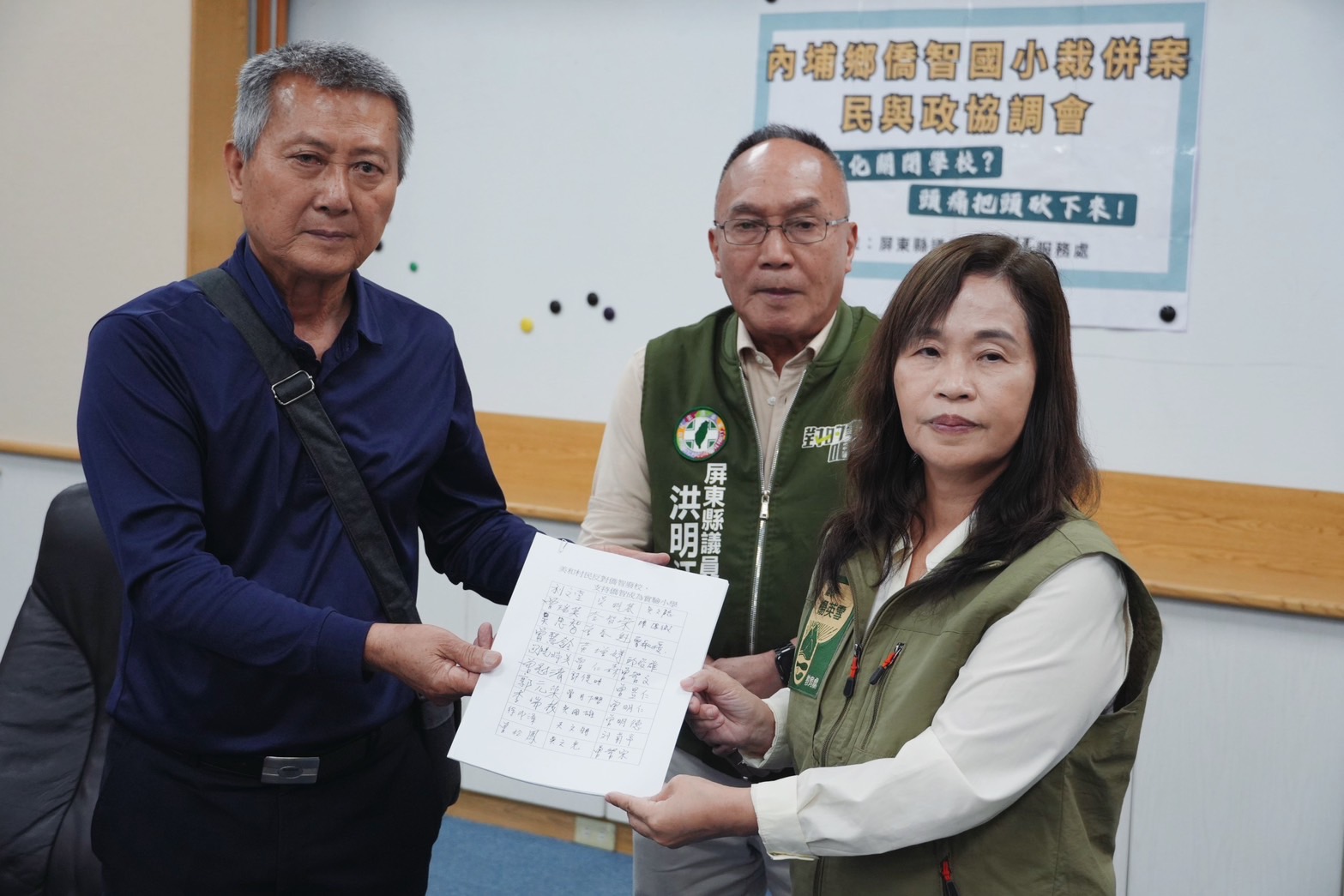 美和村長利文堂（左）今遞交400份村民的連署陳情書，盼縣府暫緩停辦程序，縣府教育處長楊英雪（右）收下陳情書。